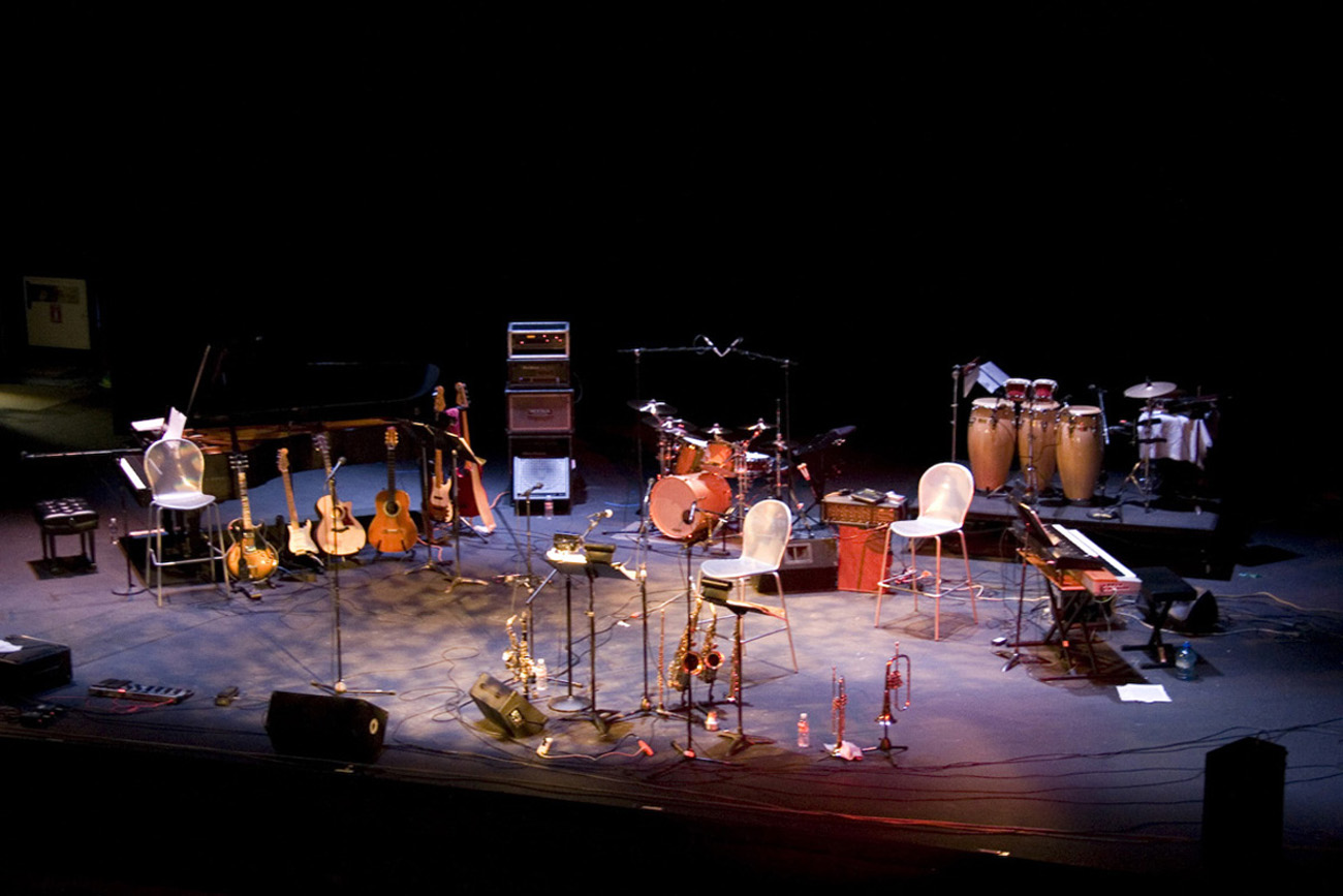 Stage with music equipment. Drums, guitars, horns, mics, and amps.